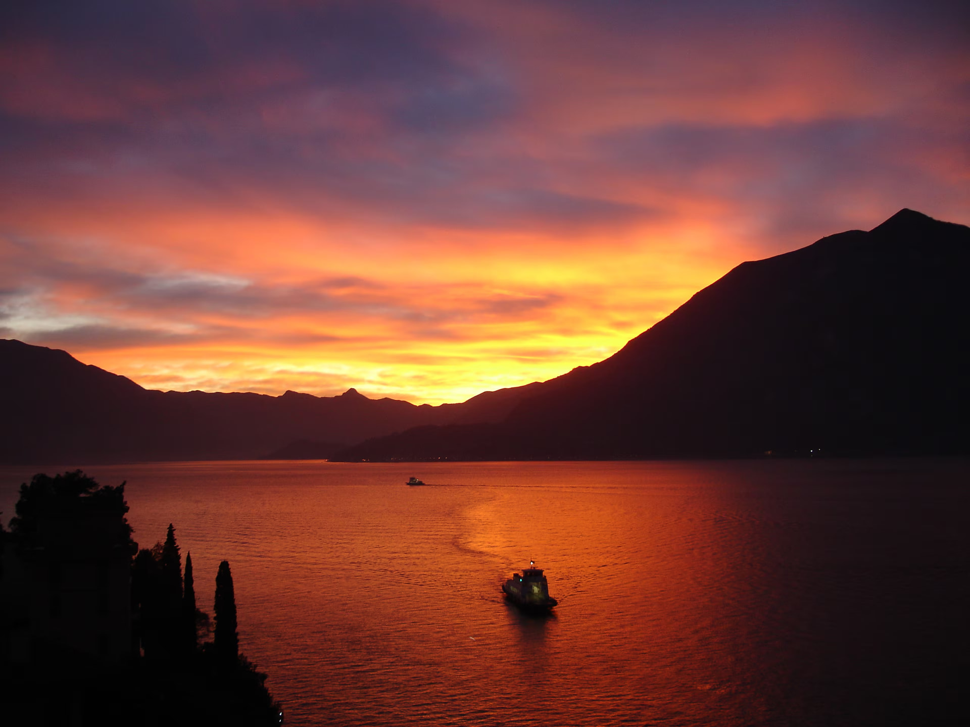 Ferry crossing Lake Como at sunset